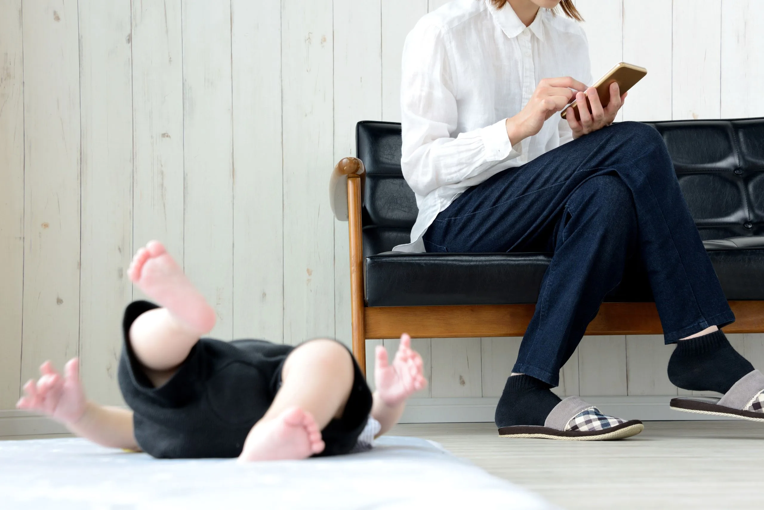 Babys und Mutter weinen mit Smartphone im Wohnzimmer
